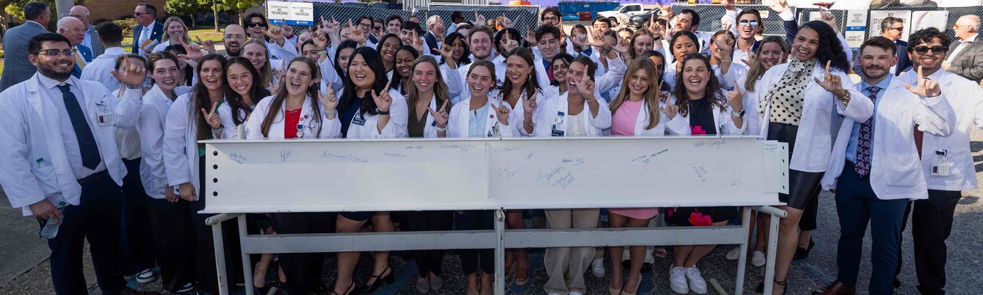 college of medicine students with signed construction beam