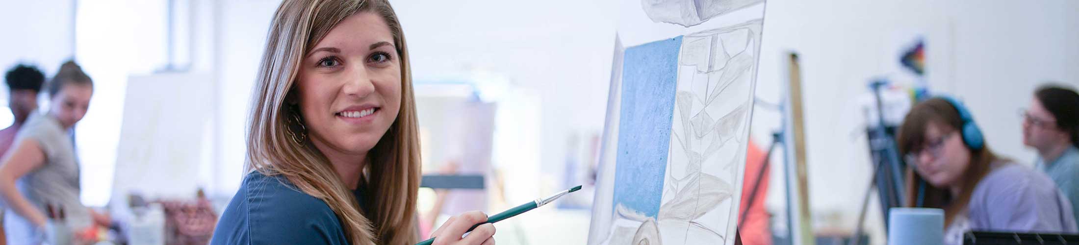 Female student drawing on canvas