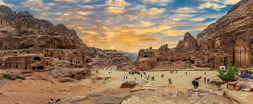 Desert scene with people hiking and viewing landcape.