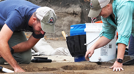 Students digging on a archaeological dig.