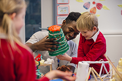 Teacher working with student on art project.