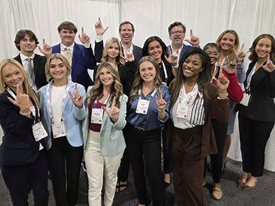 Real Estate Students holding up J hand for Jaguars.