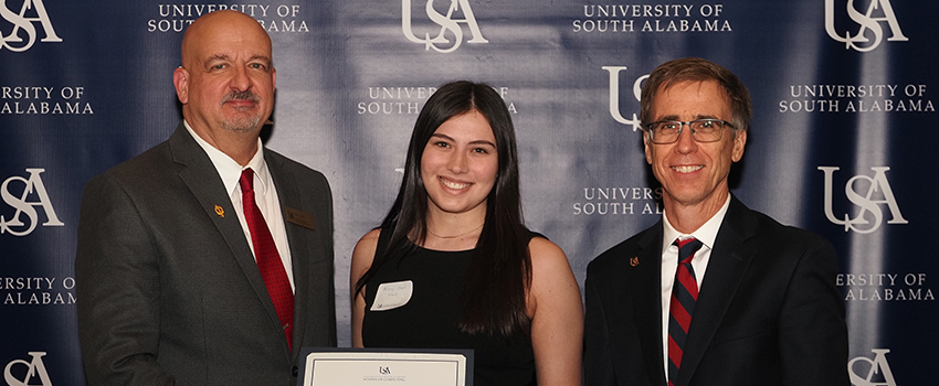 Dr. Pardue and Dr. Landry handing a certificate to a student