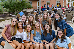 Students smiling in a group at the outdoor deck of the campus rec center.