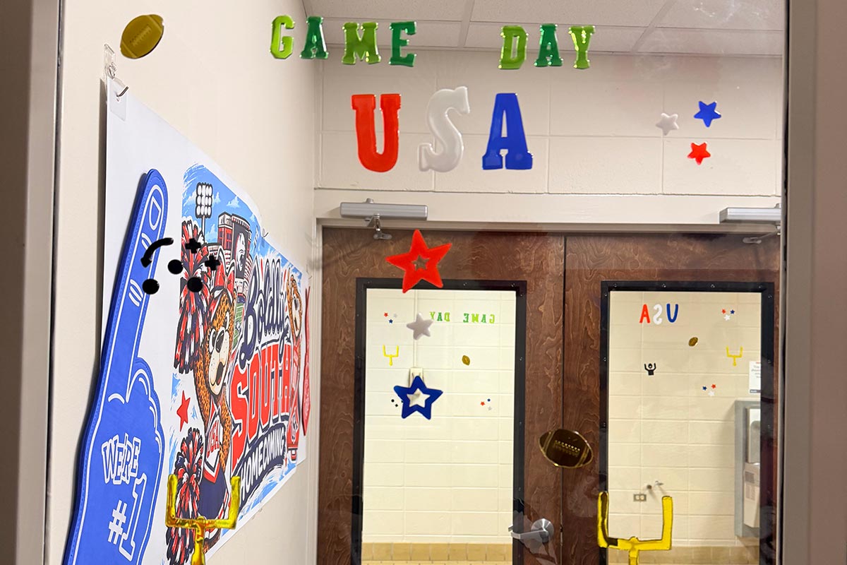 Hall and door decorated for Homecoming with sign, foam finger, and Game Day USA.
